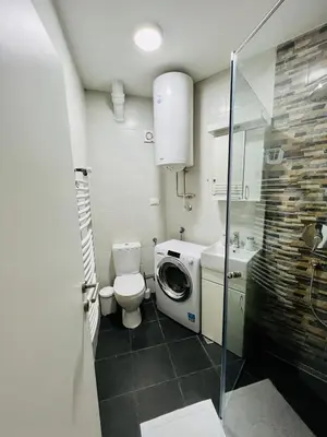 a bathroom with a toilet sink and a washing machine at Iskra Apartment in Belgrade
