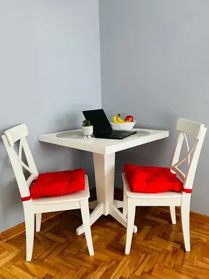 a white table with two chairs and a laptop on it at Iskra Apartment in Belgrade