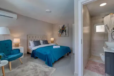 a bedroom with a blue bed and a blue chair at Bungalow Lux in Novi Banovci