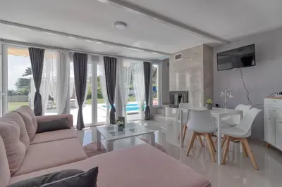 a living room with a couch and a table at Bungalow Lux in Novi Banovci