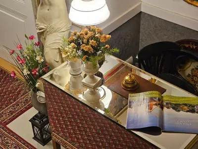 a table with flowers in vases and a book at VANSVEL Boutique Apartment 7 in Belgrade