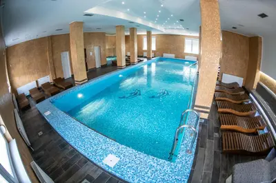 a pool in a hotel with chairs around it at Apartmani Elixir in Nova Pazova