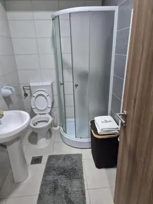 a bathroom with a shower and a toilet and a sink at Apartmani Elixir in Nova Pazova