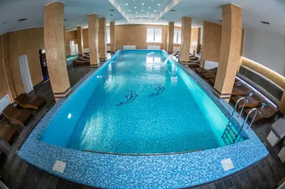 a pool in a hotel room with a large swimming pool at Apartmani Elixir in Nova Pazova