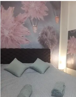 a bedroom with a bed with pink flowers on the wall at Libero78 in Vračar (historical)