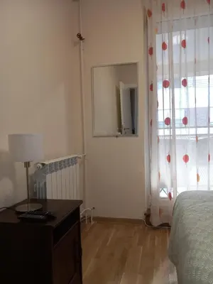 a bedroom with a bed and a dresser and a window at Libero78 in Vračar (historical)