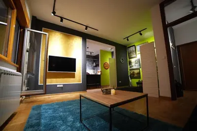 a living room with a table and a tv at Turquoise orange, the art of vacation in Belgrade in Vračar (historical)
