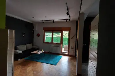 a living room with a couch and a table at Turquoise orange, the art of vacation in Belgrade in Vračar (historical)