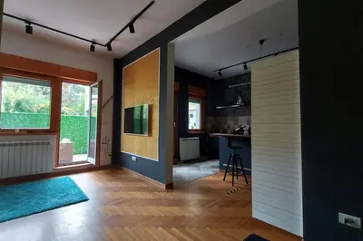 a living room with a kitchen and a hallway with a door at Turquoise orange, the art of vacation in Belgrade in Vračar (historical)