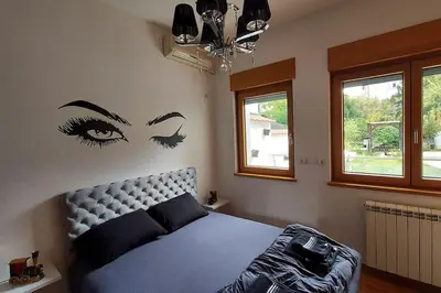 a bedroom with a bed with eyes on the wall at Turquoise orange, the art of vacation in Belgrade in Vračar (historical)