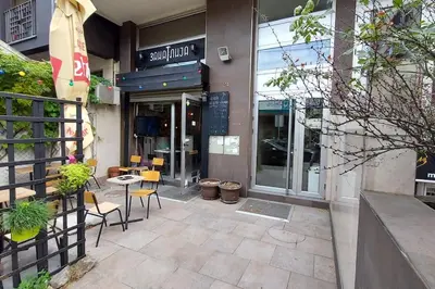 a store front with chairs and tables outside of a building at Turquoise orange, the art of vacation in Belgrade in Vračar (historical)