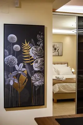 a bedroom with a painting of flowers on the wall at N10 Apartment in Belgrade