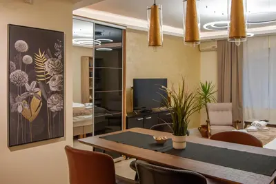 a dining room with a table and a living room at N10 Apartment in Belgrade