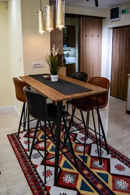a dining room table and chairs on a rug at N10 Apartment in Belgrade