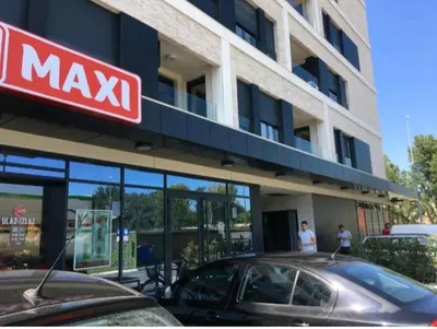 a mayx building with a car parked in front of it at West 65 apartment in Belgrade