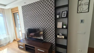 a living room with a tv on a wall at West 65 apartment in Belgrade