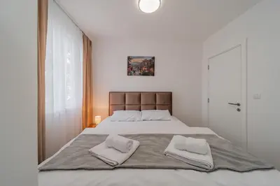 a bedroom with a large bed with two towels on it at M Apartments in Belgrade