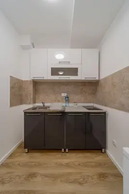 a kitchen with white cabinets and a sink at M Apartments in Belgrade