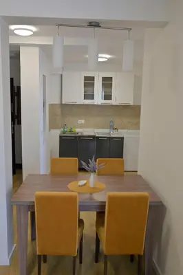 a kitchen with a wooden table and chairs at M Apartments in Belgrade