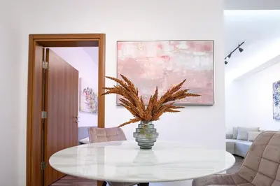a white dining room with a table with a plant on it at Marshal Dedinje in Belgrade