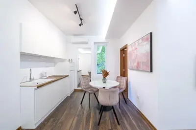 a kitchen with white cabinets and a table and chairs at Marshal Dedinje in Belgrade