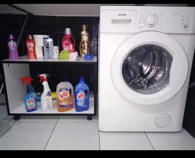 a white washing machine in a bathroom with bottles of cleaner at Happy House in Belgrade