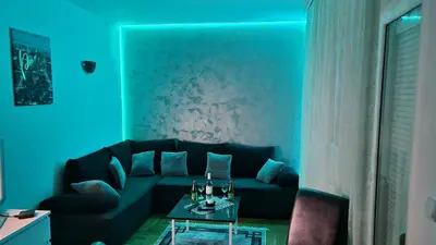 a living room with a black couch and a table at Apartman Nikola in Žarkovo