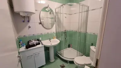a green and white bathroom with a sink and a toilet at Apartman Nikola in Žarkovo