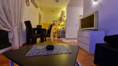 a living room with a table and a tv at Apartman Nikola in Žarkovo