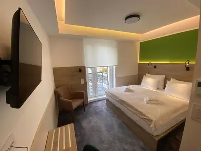 a bedroom with a bed and a green wall at Konak Stella in Belgrade