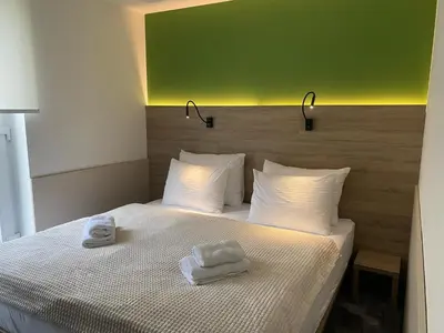 a bedroom with a bed with two towels on it at Konak Stella in Belgrade