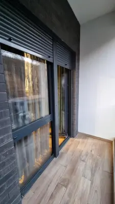 an empty room with windows and a wooden floor at Alek Place in Novi Beograd