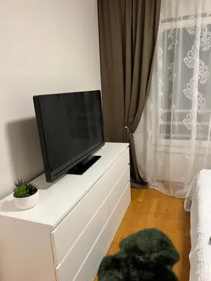 a flat screen tv sitting on top of a white dresser at M&M 22 in Belgrade