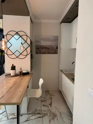 a kitchen with a wooden table and a chair at M&M 22 in Belgrade