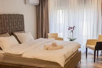 a bedroom with a bed with a towel on it at Perla Lux apartmani in Inđija
