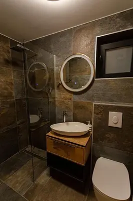 a bathroom with a sink and a toilet and a mirror at Perla Lux apartmani in Inđija