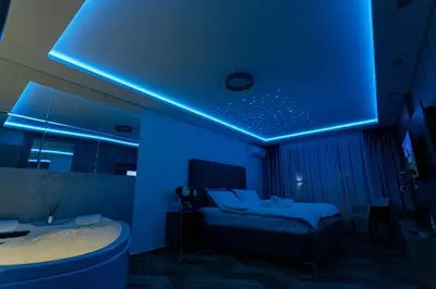 a blue room with a bed and a tub at Perla Lux apartmani in Inđija