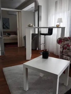 a living room with a white table and a chair at Apartman 51 in Vračar (historical)