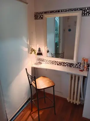 a bathroom with a vanity with a chair and a mirror at Apartman 51 in Vračar (historical)