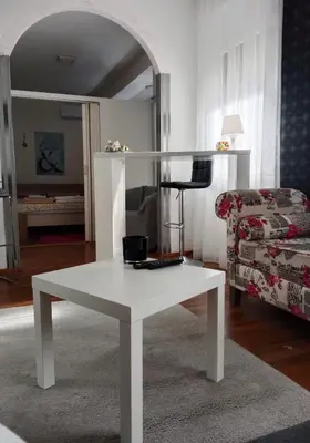 a white coffee table in a living room with a couch at Apartman 51 in Vračar (historical)