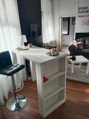 a white desk in a living room with a chair at Apartman 51 in Vračar (historical)