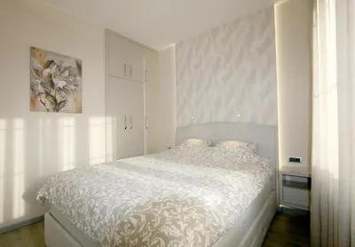 a bedroom with a bed with a white comforter at Apartment Div 2 in Dušanovac (historical)