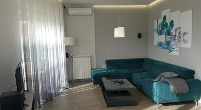 a living room with a green couch and a table at Apartment Div 2 in Dušanovac (historical)
