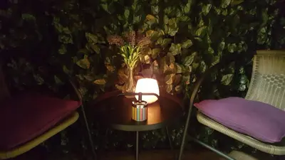 a lamp on a table next to two chairs at Apartment Div 3 in Dušanovac (historical)