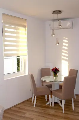 a dining room with a table and chairs and a window at Apartment Div 1 in Dušanovac (historical)