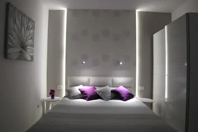 a bedroom with a large bed with purple pillows at Apartment Div 1 in Dušanovac (historical)