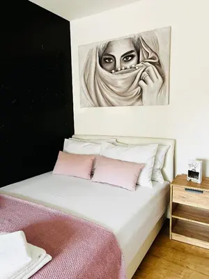 a painting of a woman is above a bed at Apartment Black Diamond - Vracar, Belgrade in Belgrade