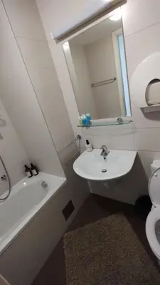 a bathroom with a sink and a tub and a mirror at Apartment Belville, Suncokret 26 in Novi Beograd
