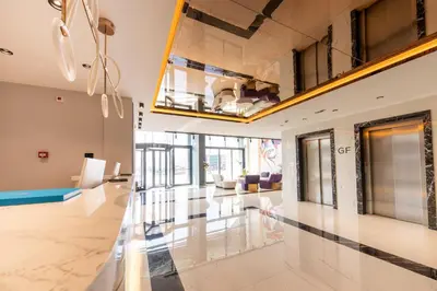 a large room with a lobby with tables and chairs at Calisi Hotel in Belgrade