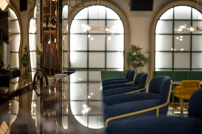 a waiting room with blue chairs and a glass table at Calisi Hotel in Belgrade